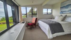 a bedroom with a bed and a large window at Whareupoko in Waimarama