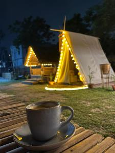 a cup of coffee sitting on a table next to a tent at Canopy Haven in Siliguri