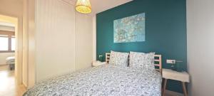 a bedroom with a bed with a blue wall at Vista al Mar 2 Peñiscola in Peniscola +22 photos