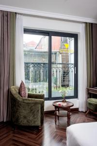 a living room with a chair and a large window at Eli Suites in Hanoi +112 photos