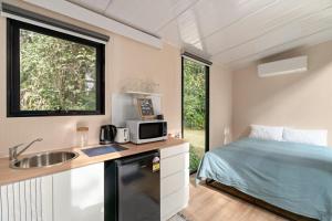 a small kitchen with a sink and a bed in a room at Natural Age by Tiny Away in Bahrs Scrub