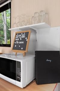 a microwave oven with a sign on top of it at Natural Age by Tiny Away in Bahrs Scrub