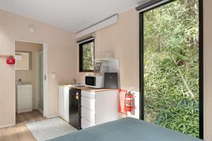 a kitchen with a refrigerator and a microwave at Natural Age by Tiny Away in Bahrs Scrub