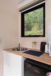 a kitchen with a sink and a window at Natural Age by Tiny Away in Bahrs Scrub