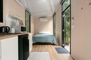 a small kitchen with a bed in a tiny house at Natural Age by Tiny Away in Bahrs Scrub +18 photos