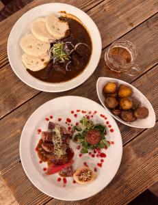 three plates of food on a wooden table at Penzion Kouty in Loučná nad Desnou