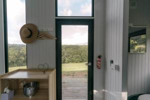 a door to a kitchen with a view of a field at Rainforest Sunsets by Tiny Away in Kuranda