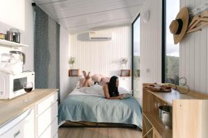 a woman laying on a bed in a kitchen at Rainforest Sunsets by Tiny Away in Kuranda