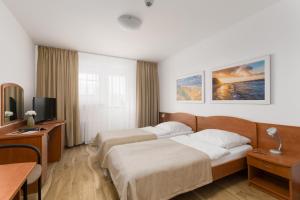 a hotel room with two beds and a television at San Medical Spa in Kołobrzeg +52 photos