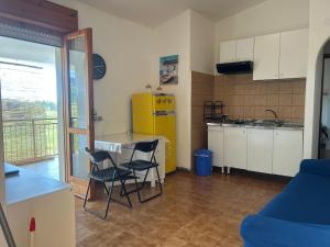 a kitchen with a table and chairs in a room at Casa COMER GRISOLIA in Cirella