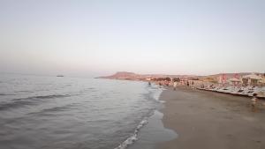 a beach with chaise lounges and the ocean at Casa Nefeli in Karteros
