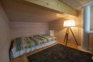a bedroom with a bed and a floor lamp at Rantarovio in Alvajärvi