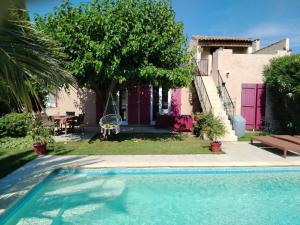 a swimming pool in front of a house at Villa Luberon Piscine Pétanques in Cavaillon