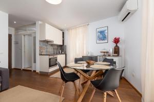 a kitchen and dining room with a table and chairs at Apartment Lassy by Irundo in Rovinj