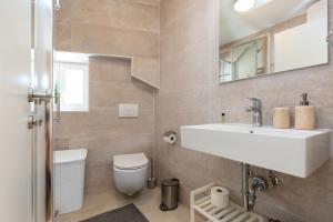 a bathroom with a sink and a toilet and a mirror at Apartment Lassy by Irundo in Rovinj