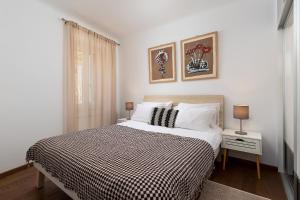 a bedroom with a bed with a black and white blanket at Apartment Lassy by Irundo in Rovinj