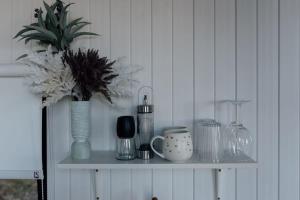 a shelf with vases and other items on it at Tiny Tamborine 1 by Tiny Away in Wongawallan