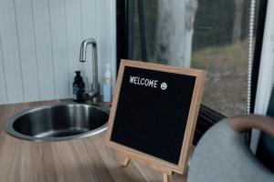 a welcome sign in front of a sink at Tiny Tamborine 1 by Tiny Away in Wongawallan