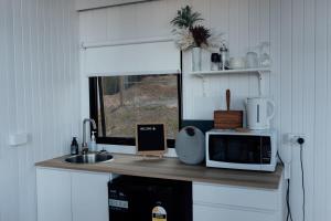 a kitchen with a counter with a microwave and a sink at Tiny Tamborine 1 by Tiny Away in Wongawallan