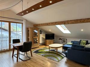 a living room with a couch and a table at Ferienwohnung Scheibenwand-Loft in Aschau im Chiemgau