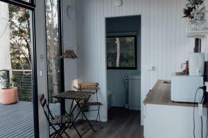 a kitchen with a table and chairs and a refrigerator at Tiny Tamborine 1 by Tiny Away in Wongawallan