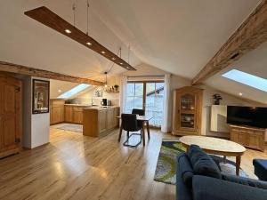 a kitchen and living room with a couch and a table at Ferienwohnung Scheibenwand-Loft in Aschau im Chiemgau