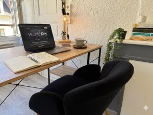 a desk with a laptop and a chair with a book at Chic & Lumineux / Évreux Centre / WiFi in Évreux