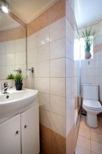 a bathroom with a white sink and a toilet at Art Gallery Hotel Athens in Athens