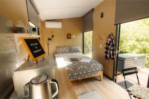 a small room with a bed and a table in it at Tranquility Tiny House by Tiny Away in Owaka