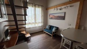a living room with a staircase and a blue chair at Bombyx Inn in Bergamo