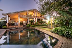 a house with a swimming pool in front of it at Stille Woning Guesthouse in White River