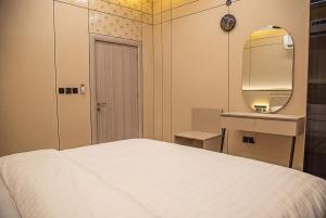 a bedroom with a white bed and a mirror at أجنحة لوسيل 3 Lucille Suites in Jeddah
