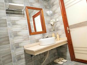 a bathroom with a sink and a mirror at 八零年代客栈 in Hanqiyu