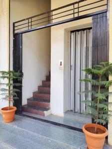 a entrance to a building with two potted plants at Hotel Mayur Lodge in Bijāpur