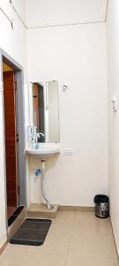 a bathroom with a sink and a mirror at Hotel Mayur Lodge in Bijāpur