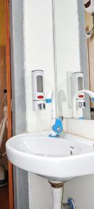 a white sink in a bathroom with a mirror at Hotel Mayur Lodge in Bijāpur