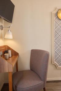 a chair sitting next to a desk with a lamp at Hotel Boris V. by Happyculture in Levallois-Perret