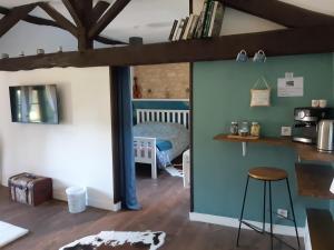 a room with a bed and a table and a stool at The Old Forge in La Ressière