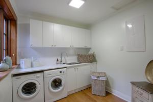 a kitchen with a washing machine and a sink at The Terrace - Luxury Villa in the heart of Oamaru in Oamaru