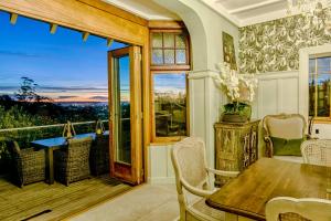 a dining room with a table and a balcony at The Terrace - Luxury Villa in the heart of Oamaru in Oamaru