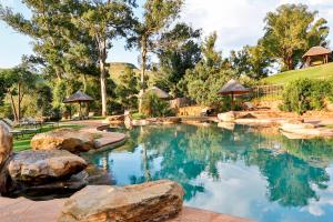 a swimming pool in a backyard with rocks and trees at Montusi Mountain Lodge in Bonjaneni