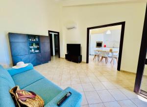 a living room with a blue couch and a dining room at Villa Giovanna - Residence with Pool in Campofelice di Roccella