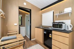 a kitchen with a microwave on top of a counter at Wildlife Haven by Tiny Away in Agnes Water
