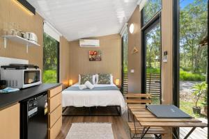 a bedroom with a bed and a desk with a laptop at Wildlife Haven by Tiny Away in Agnes Water