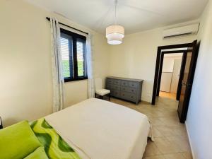 a bedroom with a white bed and a window at Villa Giovanna - Residence with Pool in Campofelice di Roccella +21 photos