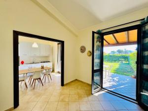 a kitchen and dining room with a sliding glass door at Villa Giovanna - Residence with Pool in Campofelice di Roccella