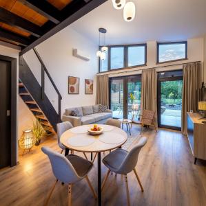 a living room with a table and chairs at White Lotus Mini Loft House in Mezőkövesd