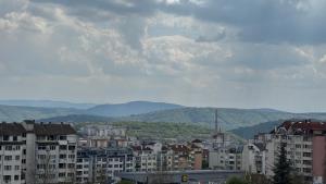 a city with buildings and mountains in the background at Active Homes in Veliko Tŭrnovo