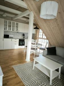 a living room with a couch and a table at Loft Apartment Self Check-in in Mažeikiai