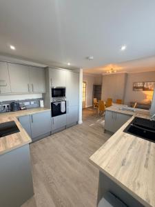 a kitchen with white cabinets and a living room at The Villas holiday homes in Horden +28 photos